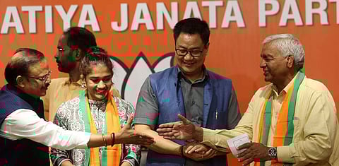 Wrestler Babita Phogat and her father Mahavir Singh Phogat join Bharatiya Janata Party in the presence of Union Sports Minister Kiren Rijiju at BJP headquarters, in New Delhi. (Photo | Shekhar yadav)