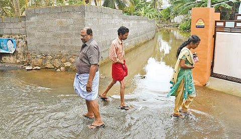 Residents wading through the contaminated water from Kariyilthodu at Asan Nagar B P Deepu