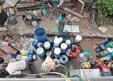 People fill containers with water from a tanker. (Photo | EPS)