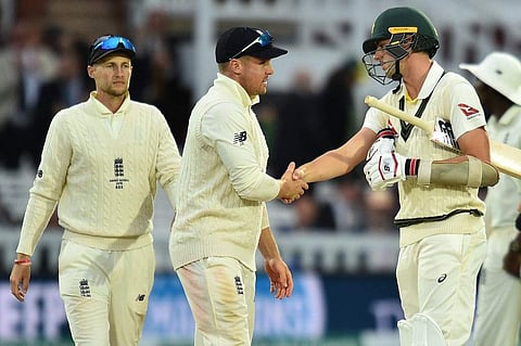 England's captain Joe Root (L) and England's Jason Roy (C) shake hands with Australia's Pat Cummins following the last over on the fifth day of the second Ashes cricket Test match. (Photo | AFP)