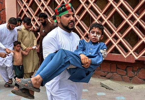A volunteer carries an injured boy to a hospital, following multiples of bomb blasts in Jalalabad on August 19, 2019. (Photo | AFP)