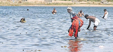 Selvam, a fisherman from Musiri, Tiruchy, collecting clothes left by devotees in the Cauvery river | M K Ashok Kumar