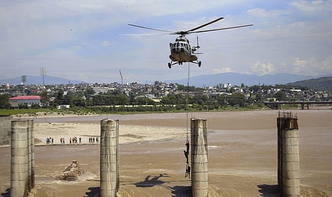 A chopper of the Indian Air Force approaches to airlift two persons stuck on an under-construction bridge on the flooded Tawi River in Jammu Monday August 19 2019. | PTI