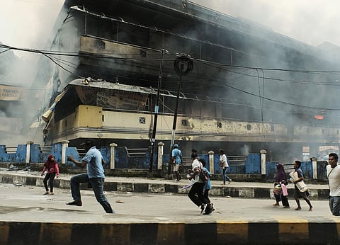 People flee as the local market is seen burning during a protest in Fakfak, Papua province, Wednesday, Aug. 21, 2019. | ( Photo | AP )