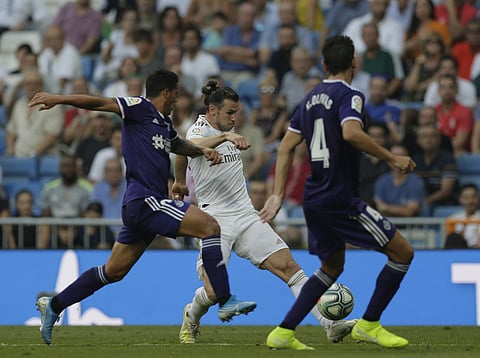 Real Madrid's Gareth Bale, center, vies for the ball with Valladolid's Pedro Porro during the Spanish La Liga soccer match between Real Madrid and Valladolid at the Santiago Bernabeu stadium in Madrid, Spain, Saturday, Aug. 24, 2019. | AP