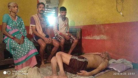 Maheshwar Shetiya lies at his house at Yellapur village in Uttara Kannada district. His wife and two sons are also seen. (Photo | EPS)