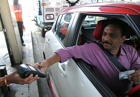 A person using debit card against toll payment at Neelambur Toll plaza. | (A Raja Chidambaram | EPS)