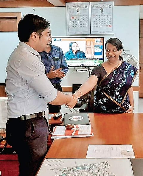 District Collector S Suhas congratulating T V Shabna, who received the best employee of the month award