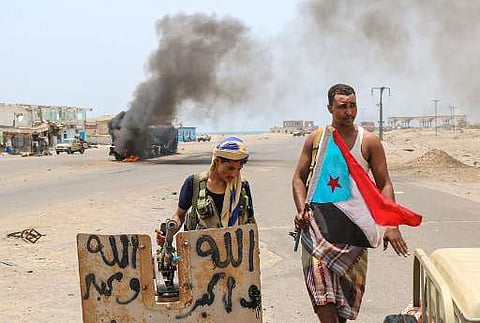 Fighters of the UAE-trained Security Belt Force, dominated by members of the Southern Transitional Council (STC) which seeks independence for south Yemen, stand atop a military jeep with a separatist flag in front of an oil tanker set ablaze during clashe