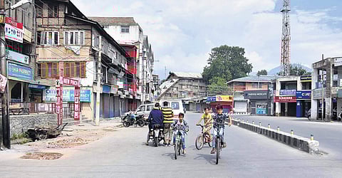 Children with their bicycles on a deserted road in Srinagar. Traffic movement remains restricted as restrictions were again imposed in Kashmir Valley on Friday. | (Zahoor Punjabi | EPS)