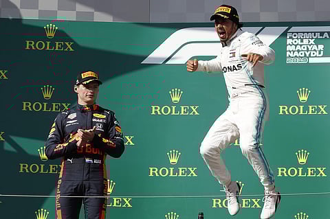 Mercedes driver Lewis Hamilton, right, of Britain celebrates on the podium with second placed Red Bull driver Max Verstappen, of the Netherlands, after winning the Hungarian Formula One Grand Prix at the Hungaroring racetrack in Mogyorod, northeast of Bud