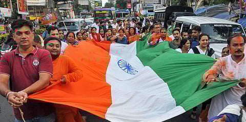 BJP supporters celebrate with a giant National flag te Central government's move to revoke Article 370 in Jammu and Kashmir. (Photo | PTI)