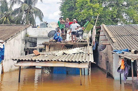 People on top of their house in flood-hit Devipatnam mandal in East Godavari on Tuesday; (below) flood water at Polavaram spillway (Photo |EPS)