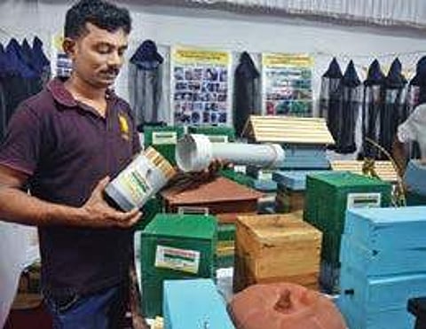 Binu P T explaining about his unique beehive at his stall;