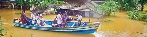 People stranded in houses following heavy rain at Thengilakkadavu in Kozhikode being evacuated in a fishing boat on Thursday | Manu R Mavelil