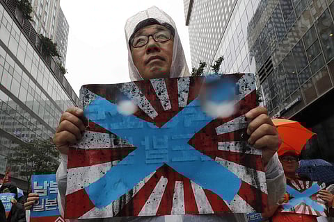 South Korean protesters hold Japanese rising sun flags during a rally to mark the South Korean Liberation Day from Japanese colonial rule, in downtown Seoul, South Korea. South Korea has formally asked the International Olympic Committee to ban the Japane
