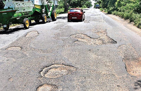 Vehicles move through the damaged Karimnagar-Warangal highway on Tuesday (Photo |EPS)
