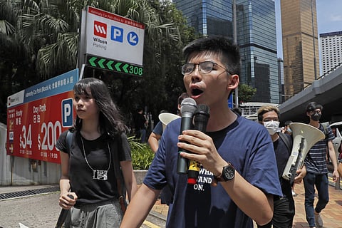 Pro-democracy activist Joshua Wong, center left, speaks as protesters surround the police headquarters in Hong Kong. ( File Photo | AP )