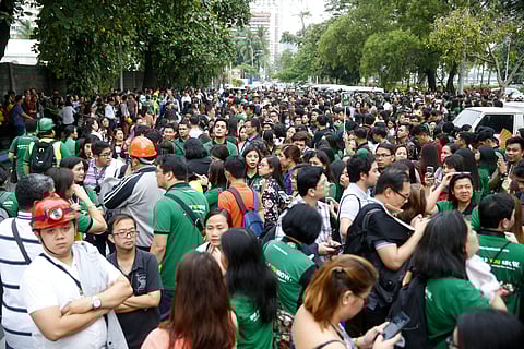 Office employees, some wearing hard hats, gather in the open as they file out of their building following a magnitude 5.5 that rocked some areas of the country's north, including in the capital, that also briefly disrupted train services. ( Photo | AP )