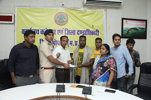 Brave heart swimmer being honoured by district collector and SP in Bhopal on Saturday. | (Photo | EPS)