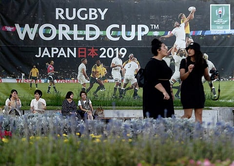 People walk past a banner promoting the upcoming Japan 2019 Rugby World Cup in Kobe. (Photo | AFP)
