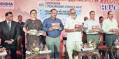 Governor Prof Ganeshi Lal unveiling ‘Tourism Booklet on Western Odisha’ during 4th Odisha Tourism Conclave in Bhubaneswar on Wednesday | Express