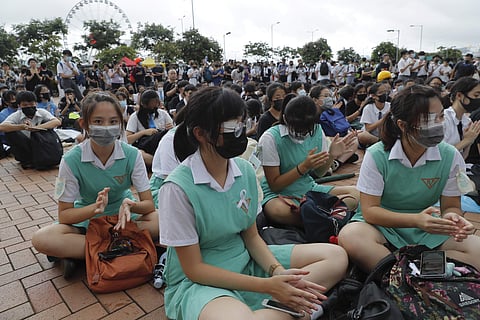 Secondary students sit on the ground during a protest at Admiralty in Hong Kong. (Photo | AP)