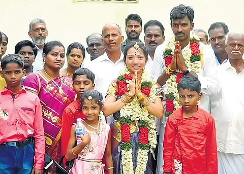 Velmurugan (30) and Ronajen Alastra (25) pose for photographs with their relatives after the marriage ceremony at T Palur on Sunday | Express