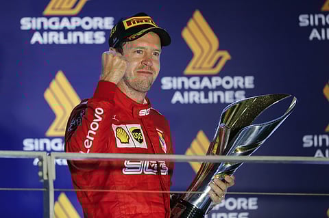 Ferrari driver Sebastian Vettel of Germany celebrates with the trophy after winning the Singapore Formula One Grand Prix. (Photo | AP)