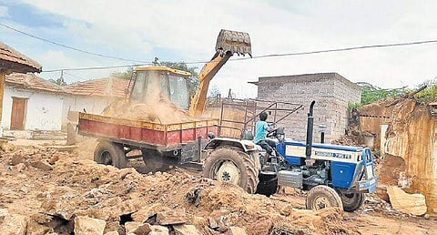An earthmover clears debris after the demolition of a house in Srigiripally
