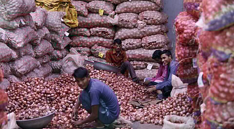 Labourers sort onions at a market in New Delhi. (Photo | Arun Kumar, EPS)