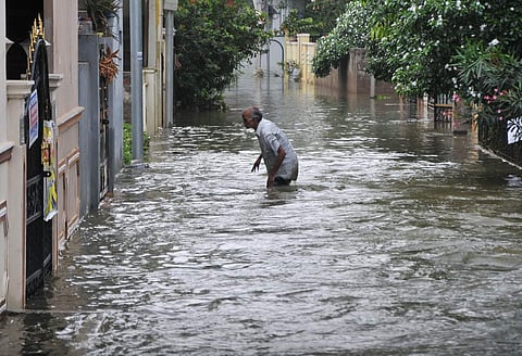 A man wades through knee deep water in Malkajgiri area of Hyderabad(Photo | S Sengabagapandiyan, EPS)