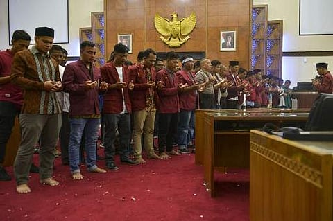 Student protesters and police officers pray for victims during a rally against the government's proposed legal reforms, in a room of the people's representative council (DPR) in Banda Aceh on September 27, 2019. (Photo | AFP)