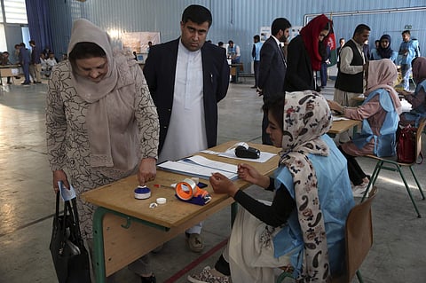 An Afghan woman, left, inks her finger at a polling station at Amani high school, near the presidential palace in Kabul, Afghanistan, Saturday, Sept. 28, 2019. | (Photo | AP)