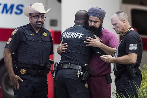 Mourners gather outside Memorial Hermann Hospital in Houston after Harris County Sheriff's Deputy Sandeep Dhaliwal was transported to the medical examiners office after he was shot and killed in the line of duty on Friday, Sept. 27, 2019. | (Photo | AP)