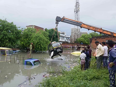 A crane pulls out an autorickshaw from a flooded area in UP's Mirzapur district. (Photo | PTI)