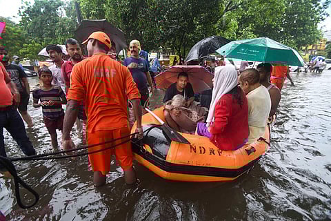 Nation Disaster Response Force workers rescue an elderly patient from flood-affected area of Bahadurpur following heavy monsoon rainfall in Patna Sunday. (Photo | PTI)