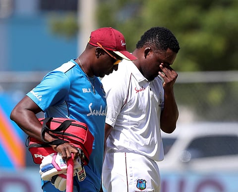 West Indies batsman Darren Bravo leaves the field escorted by a physio (Photo | AP)