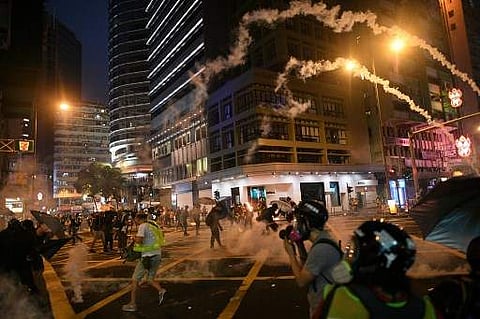 Tear gas canisters are lobbed at protesters during clashes with police following an earlier unsanctioned protest march through Hong Kong. (Photo| AFP)