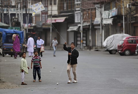 In this Tuesday, Sept. 17, 2019, photo, a Kashmiri child flies a kite outside his home in Srinagar. | (Photo | AP)