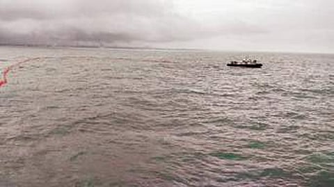 Boom barriers are placed around the sinking ship to contain possible oil spill