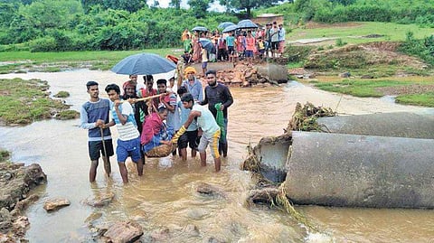 An ailing villager being carried across a damaged culvert near Solopguda on the way to hospital I Express