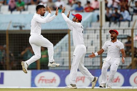 Afghanistan cricketer Rashid Khan (L) celebrates with his teammates after the dismissal of Bangladesh cricketer Musfiqur Rahim during the fourth day of the one-off cricket Test match between Bangladesh and Afghanistan at the Zohur Ahmed Chowdhury Stadium