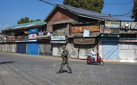 A security person stands guard at a blocked road during restrictions after the abrogration of Article 370 and bifurcation of state in Srinagar Monday September 9 2019. | PTI