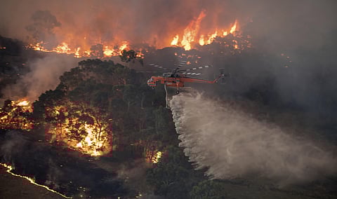 In this Monday, Dec. 30, 2019 photo provided by State Government of Victoria, a helicopter tackles a wildfire in East Gippsland, Victoria state, Australia. (Photo | AP)