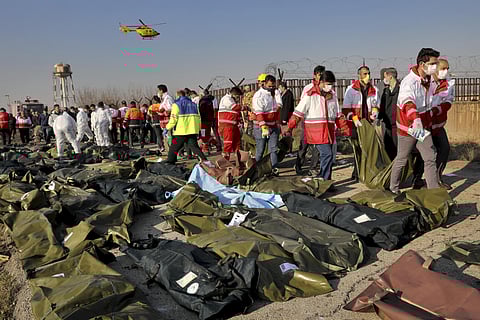 File photo of rescue workers recover bodies of victims at the scene where a Ukrainian plane crashed in Shahedshahr, southwest of Tehran. (Photo | AP)