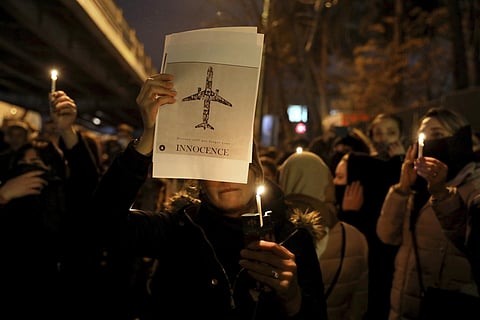 People gather for a candlelight vigil to remember the victims of the Ukraine plane crash, at the gate of Amri Kabir University that some of the victims of the crash were former students of, in Tehran, Iran, Saturday. (Photo | AP)