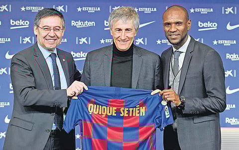 Barcelona president Josep Maria Bartomeu (L), football director Eric Abidal (R) pose with new coach Quique Setien. (Photo | AFP)