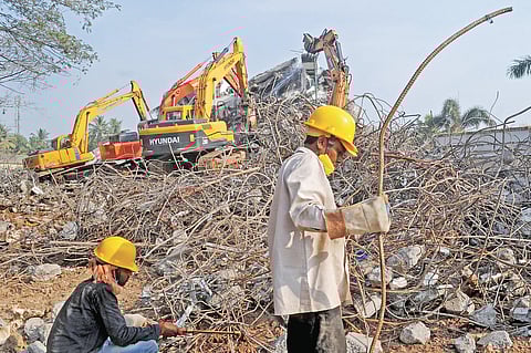 Workers removing steel rods from the debris at now-demolished Holy Faith H2O | Express