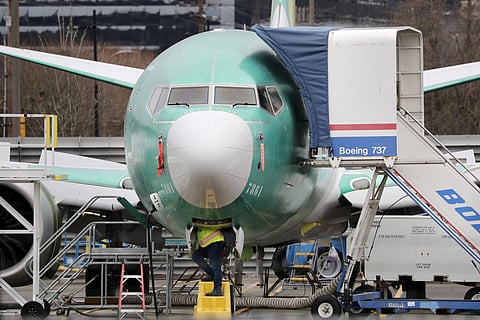 A worker looks up underneath a Boeing 737 MAX jet, in Washington. (File Photo | AP)